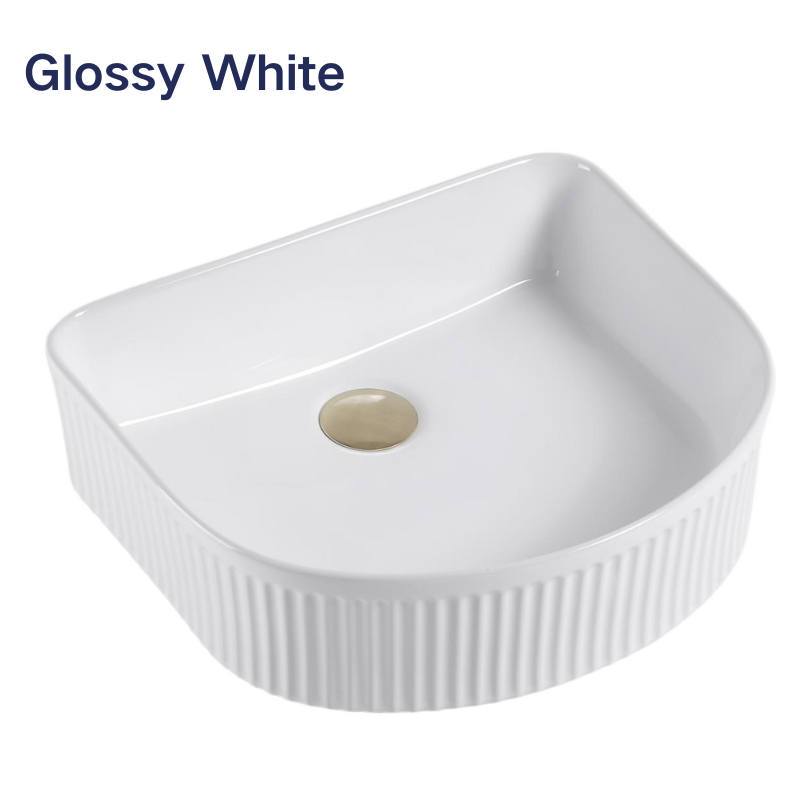 Glossy white fluted D-shaped ceramic vessel bathroom sink with a gold pop-up drain.