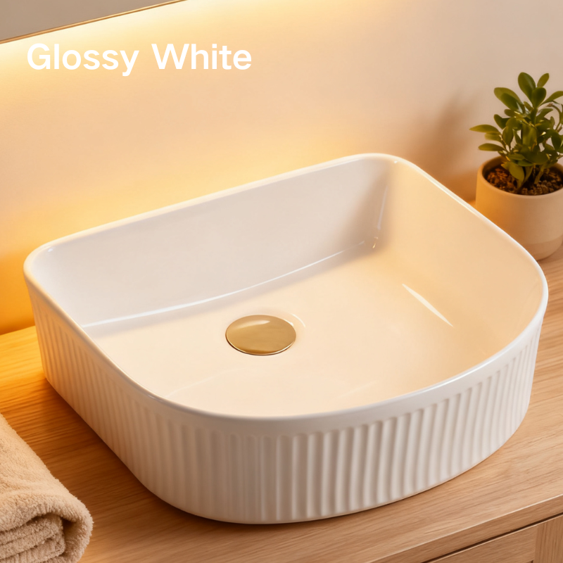 Modern glossy white fluted vessel sink with gold pop-up drain on a wooden bathroom countertop.