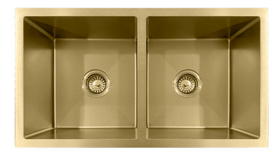 Top-down view of a brushed gold double-bowl undermount kitchen sink with drain strainers.