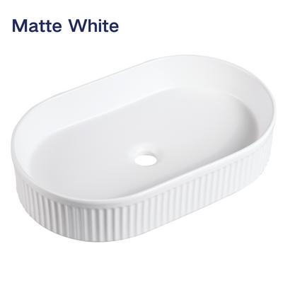 Matte white oval fluted vessel sink, ribbed ceramic bathroom vanity basin for modern home decor.