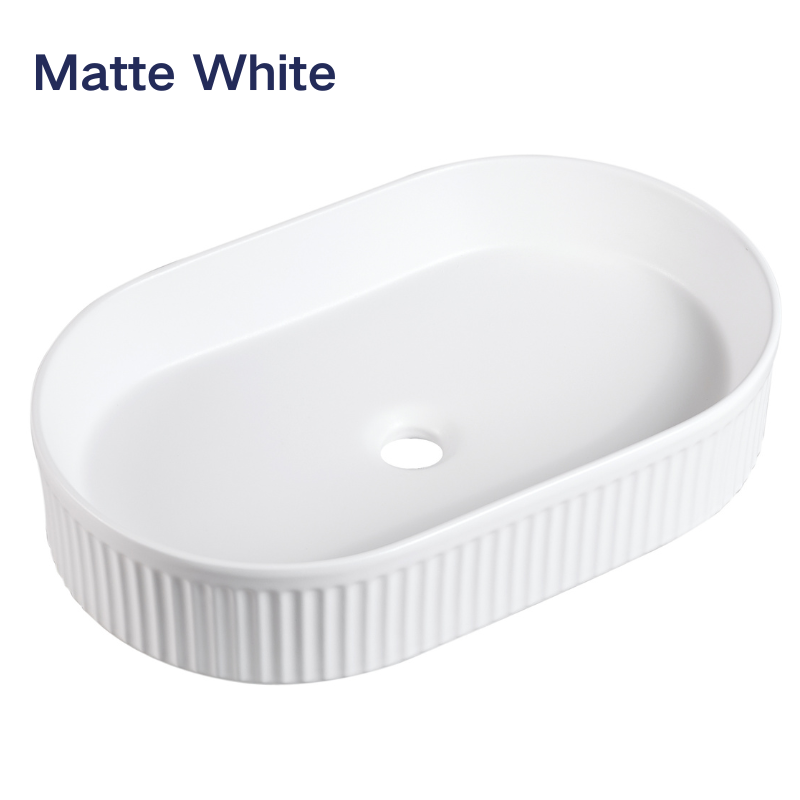 Matte white oval fluted vessel sink, ribbed ceramic bathroom vanity basin for modern home decor.