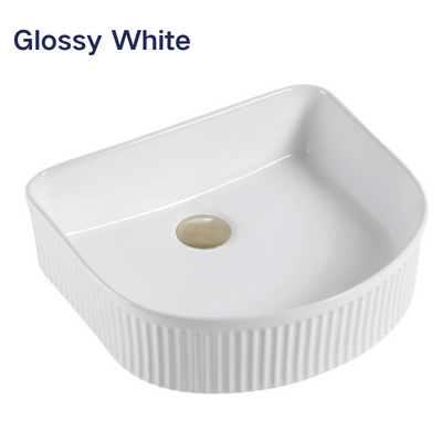 Glossy white fluted D-shaped ceramic vessel bathroom sink with a gold pop-up drain.