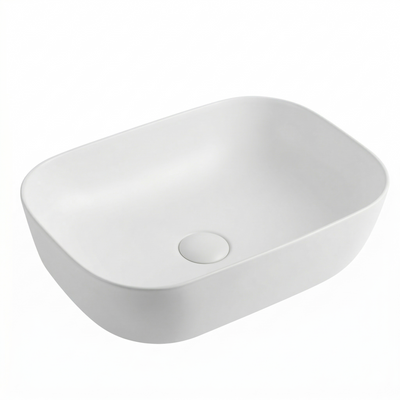Modern matte white rectangular vessel bathroom sink with rounded corners and matching drain cover.