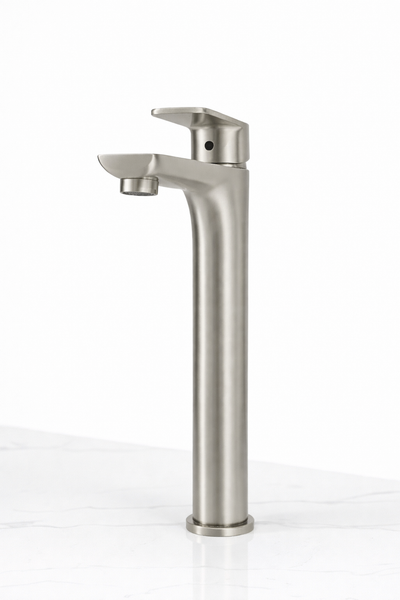 Brushed nickel tall vessel sink faucet with single lever handle on white marble countertop.