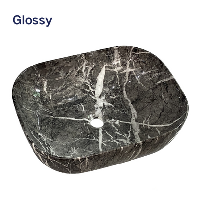 Glossy dark marble vessel sink with white veining, rectangular bathroom basin with rounded edges.