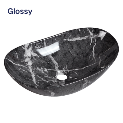 Glossy black marble effect oval vessel sink with white veining for modern bathroom vanity.