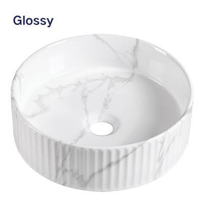Glossy white marble vessel sink with round fluted design for modern bathroom countertop.
