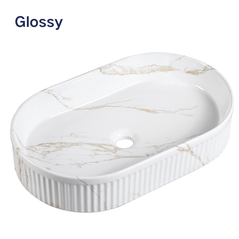 Glossy white marble oval vessel sink with gold veining and fluted exterior.