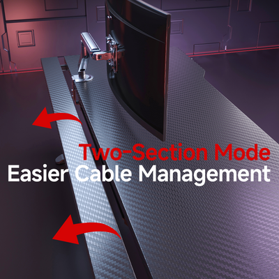Dark carbon fiber electric standing desk with two-section mode, open for easier cable management, featuring a monitor arm.