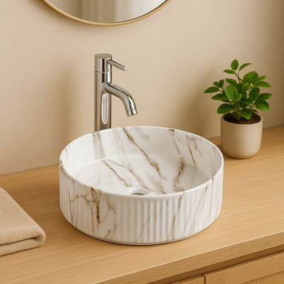 Round white marble fluted vessel sink with gold veins and chrome faucet on a wooden bathroom countertop.