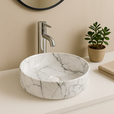 Round white marble vessel sink with grey veining and chrome faucet on a modern bathroom vanity countertop.