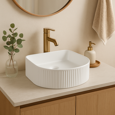 Modern white fluted square vessel sink with a gold faucet on a minimalist bathroom vanity.
