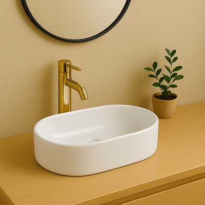 Modern white oval vessel sink with a gold faucet on a tan bathroom vanity countertop.